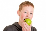 Момче яде ябълка